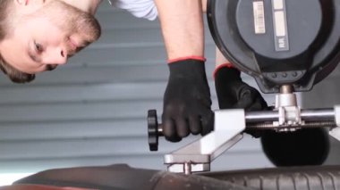 Otomobil tamircisi araba tekerlekleriyle ilgili sorun teşhis eder ve şasiyi dengeler. Profesyonel araba servisi. Dikey video