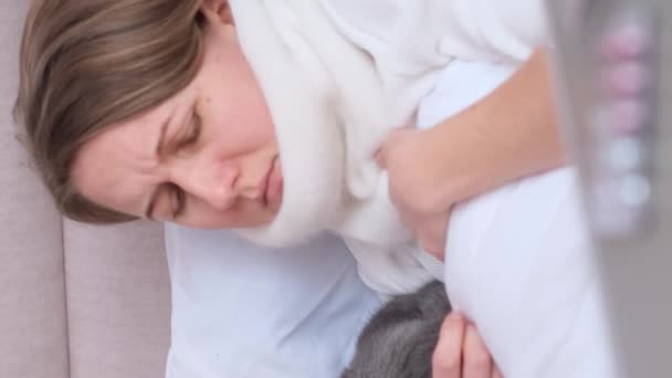 一个年轻的病人躺在床上咳嗽的画像 一个女人得了心绞痛 电晕病毒是一种疾病 在家治疗和隔离 垂直录像 — 图库视频影像