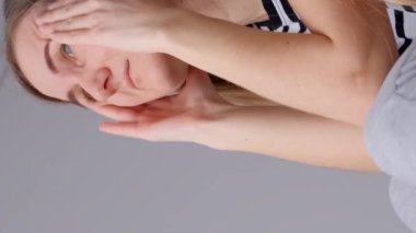 Stres altında olan bir kadının başı ağrır. Genç yaşta sağlık sorunları. Dikey video