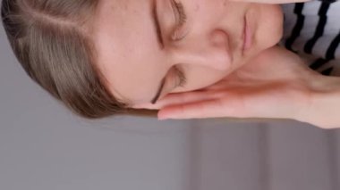 Bir kadın elleriyle şakaklarını ovuştururken baş ağrısı hisseder. Derin nefes alma ve meditasyon gibi rahatlama teknikleri. İşte yorgunluk. Dikey video