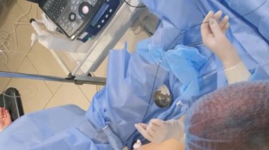 Venöz damar ameliyatının cerrahi kliniği için ameliyathanede bulunan bir phlebologist varisli damarlar için bacakları ameliyat eder. Modern, yenilikçi bir ameliyat tekniği. Dikey video