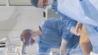 Venöz damar ameliyatının cerrahi kliniği için ameliyathanede bulunan bir phlebologist varisli damarlar için bacakları ameliyat eder. Modern, yenilikçi bir ameliyat tekniği. Dikey video