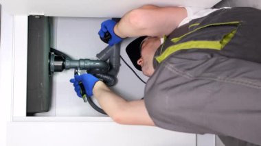 Profesyonel bir tesisatçı mutfak lavabosunu tamir ediyor. Borularda su akışı. Evine bir tesisatçı çağır. Dikey video