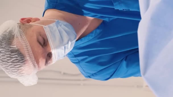 腿部手术期间静脉血管外科诊所的医生和助理 垂直录像 — 图库视频影像