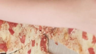 Karton bir kutudan bir dilim pizza alan bir ailenin yakın çekimi. Çocuklar ve ailelerin pizza yediği en iyi manzara. Pizza teslimatı Dikey video