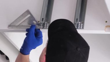 Mutfak mobilyalarının montajı sırasında profesyonel bir usta. Modern yüksek kaliteli mobilya aksesuarlarının montajı. Yeni bir daireye taşınıyorum. Dikey video
