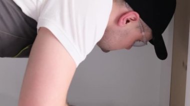 Sanatçı mutfak çekmeceleri için tesisat kuruyor. Modern yüksek kaliteli mutfak aksesuarları. Dikey video