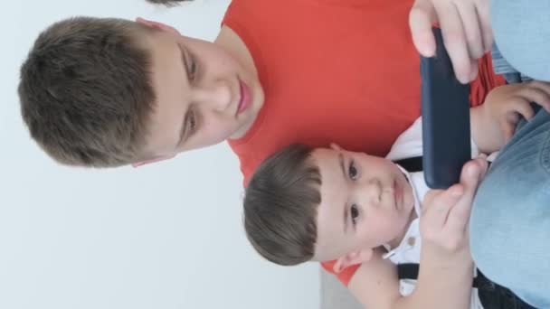 Trójka Dzieci Różnym Wieku Używa Smartfona Siedząc Kanapie Dzieci Zajmują — Wideo stockowe