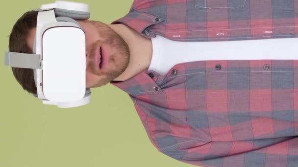 一个在虚拟现实耳机里惊讶的家伙被他看到的东西惊呆了 使用带有3D眼镜的人工智能技术 垂直录像 — 图库视频影像