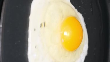 Siyah tavada tavuk yumurtası. Lezzetli, sağlıklı, protein yiyeceği. Dikey video