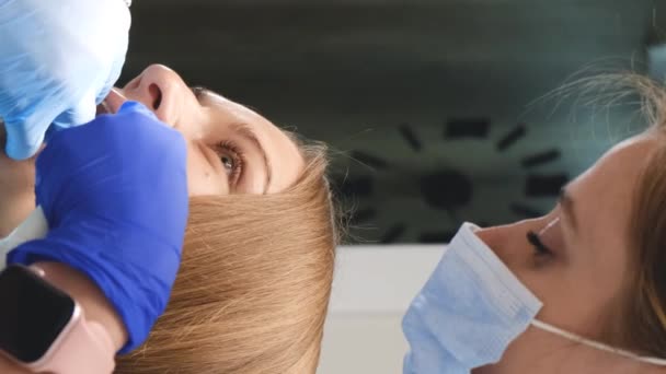 Zubař Jeho Asistent Vyšetřují Dutinu Ústní Léčí Klienta Zubní Ošetření — Stock video