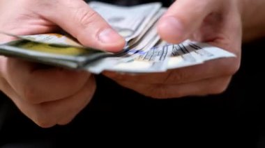 Bir adam 100 dolar sayıyor. Bir iş adamı bir tomar parayı çabucak sayar. Kapat..