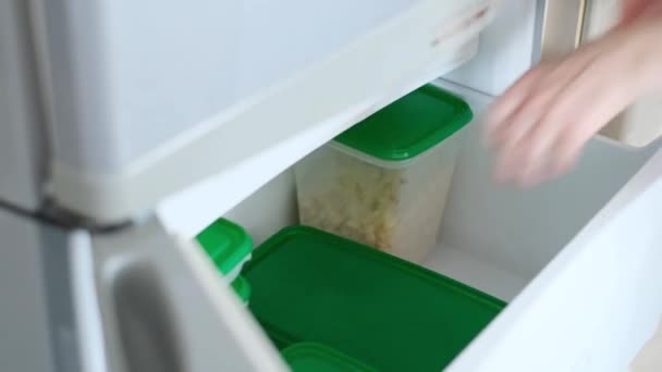 여자는 조심스럽게 준비된 음식을 저장용 컨테이너에 냉장고에 넣습니다 식품을 신선하게 — 비디오