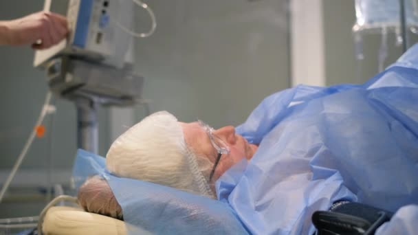 外科医生对一位老年妇女进行复杂的手术 一位麻醉后坐在手术台上的病人 — 图库视频影像