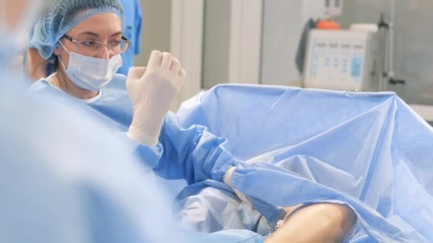 一位老年妇女在手术台上由合格的外科医生仔细观察 静脉曲张手术 — 图库视频影像