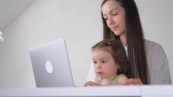 コンピューターで自宅で働く女性 小さな子供と働く母親 — ストック動画