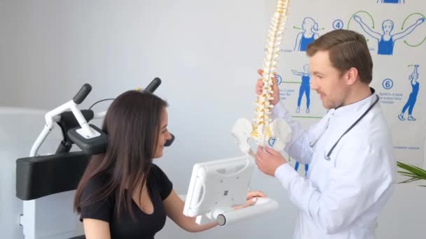 Brunetka Konsultacji Traumatologiem Lekarz Konsultuje Się Klientem Pomocą Modelu Szkieletowego — Wideo stockowe
