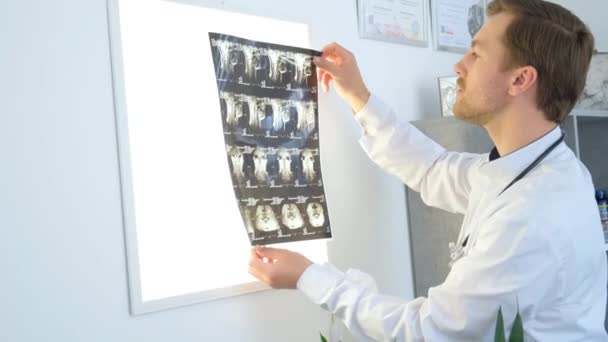 Professionelle Wirbelsäulenlogen Betrachten Das Röntgenbild Des Rückens Auf Weißem Licht — Stockvideo