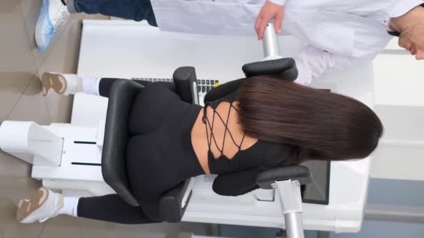 Vertical Video Professional Vertebrologist Trains Woman Back Exercise Machine Treatment — Stock Video