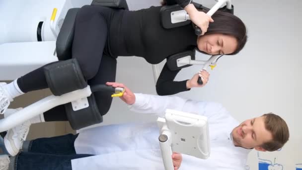 プロのトレーナーと運動をしている理学療法患者の垂直ビデオ 背中の病気の予防と治療 — ストック動画