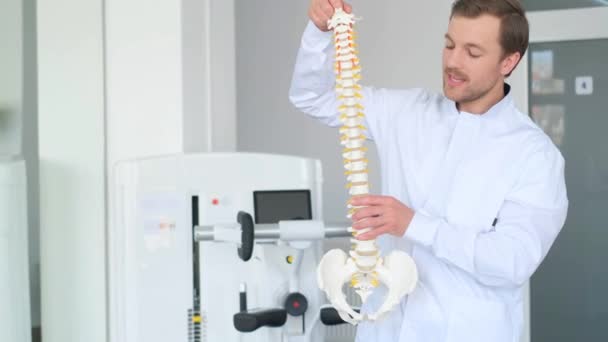 专业而有魅力的脊椎学家 穿着制服 谈论脊柱骨骼问题 脊椎学讲座 客户的视讯谘询 — 图库视频影像