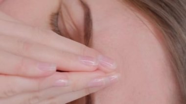 Yorgun bir kadının elleriyle yüzünü örterek yakın plan çekimleri, onu strese soktu. Panik ataklar ve sinir krizleri. Dikey video