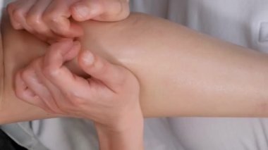 Sağlık merkezindeki genç kadın için selülit önleyici masajı kapat. Masöz hastayla çalışır, baldırlarına masaj yapar. Dikey video