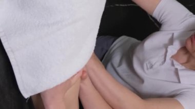 Sırt masajı aynı anda dört elle yapılır. İki profesyonel masaj terapisti hastayla ilgilenir. Sağlık hizmetleri. Dikey video