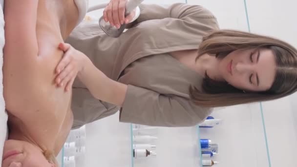 Kosmetolog Med Rulle Händerna Masserar Ryggen Med Hjälp Apparat Vertikal — Stockvideo