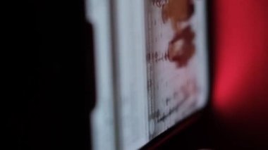 Erkek el, karanlık ışıkta parmaklarıyla akıllı telefon ekranında çalışır. İnternetten bilgi aranıyor. Akıllı telefondan video izliyorum. Dikey video