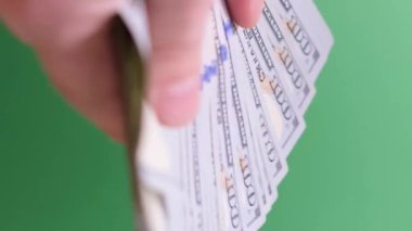 Yeşil arka planda erkek eli nakit dolarları sayıyor. Seçici odaklanma. Kromakey arka planı. Dikey video