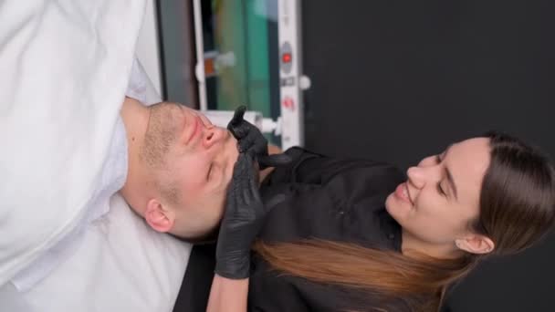 침대에 남자는 마사지를 받는데 얼굴에는 관리를 받습니다 — 비디오