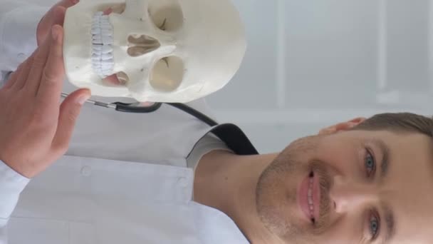 Der Arzt Hält Einen Menschlichen Schädel Den Händen Und Lächelt — Stockvideo