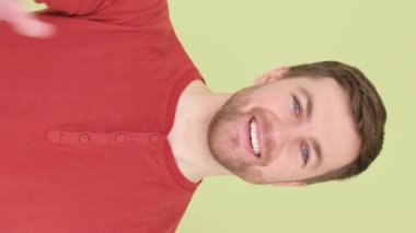 Avustralyalı adam onay veriyor, bir anlaşma işareti. Yeşil arka planda yakışıklı bir adam el hareketi gösterir. Dikey video