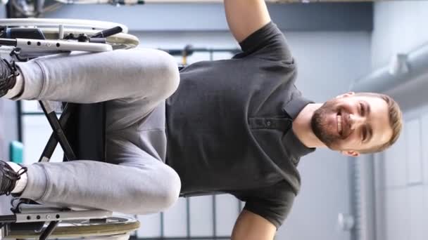 車椅子に乗っている男性は 治療用体操をしています 負傷後のリハビリテーションプロセス バーティカルビデオ — ストック動画