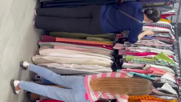 一群妇女在一家二手商店买东西 旧衣服 垂直录像 — 图库视频影像