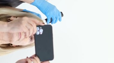 Doktor saç yapısına teşhis koyuyor. Yaşlı bir kadının trikoloğa danışması. Dikey video