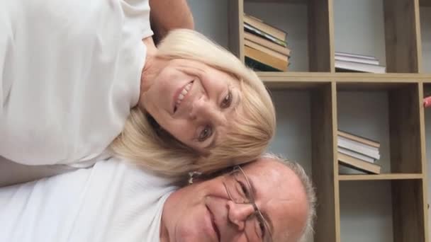 敬爱着戴眼镜的老人 微笑着拥抱妻子 看着相机 灰白头发的男人和女人摆出家庭录像的姿势 垂直录像 — 图库视频影像