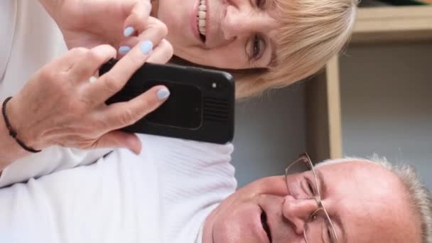 Bedstefar Bedstemor Sidder Hjemme Sofaen Ser Underholdningsprogrammer Smartphone Smilende Pensioneret – Stock-video
