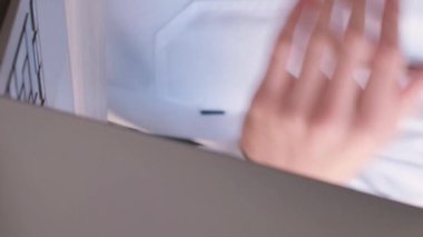 Beyaz üniformalı bir doktor internet üzerinden internet üzerinden iletişim sağlayan bir tüp ilaç sunuyor. Tıbbi danışmanlık çevrimiçi. Dikey video