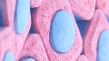 Katı çamaşır tozunun kapsüllerinin makro videosu. Çamaşır yıkama konsepti. Dikey video.