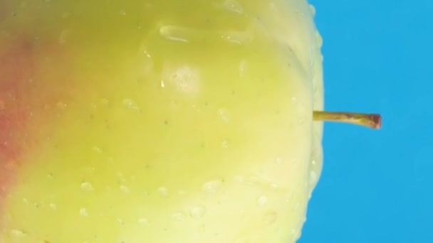 Een Appel Waterdruppels Draait Een Blauwe Achtergrond Vegetarisch Voedselconcept Verticale — Stockvideo