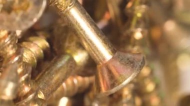 Metal screws in the furniture workshop rotate in a circle. Use of fasteners when working with wood. Macro video