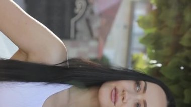 Kameraya bakan güzel, Avrupalı bir kadının portresi. Yoga konsepti. Dikey video.