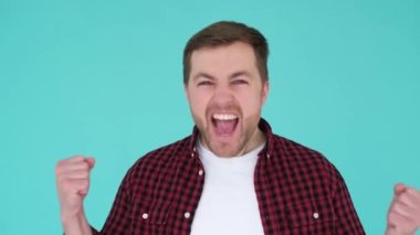 Yakışıklı adam stüdyo geçmişinde neşe gösteriyor. 30 yaşında Avrupalı görünümlü bir adam..