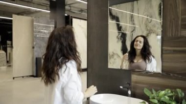 Bir kadın bir tasarım servisinde tuvaletin içini inceliyor. Modern banyo..