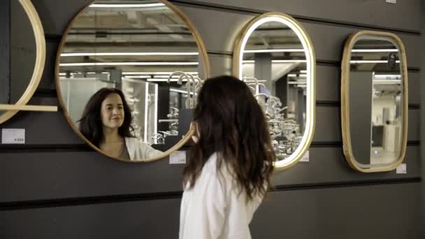 女性はトイレの鏡を調べる トイレの再建について アイデアを修復する — ストック動画