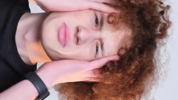 Närbild Porträtt Överraskad Rödhårig Lockig Pojke Ljus Bakgrund Huvudvärk Problem — Stockvideo
