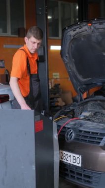 Otomobil tamircisi, klima hava kompresörü soğutma sistemi sızıntısı için araba teftişi yapıyor. Oto tamircisi olduğundan şüpheleniliyor. Dikey video