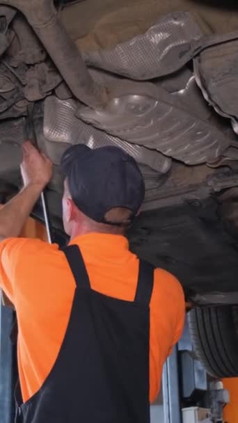 Bilmekaniker Overalls Reparerer Hjulene Bil Der Står Elevator Værksted Lodret – Stock-video